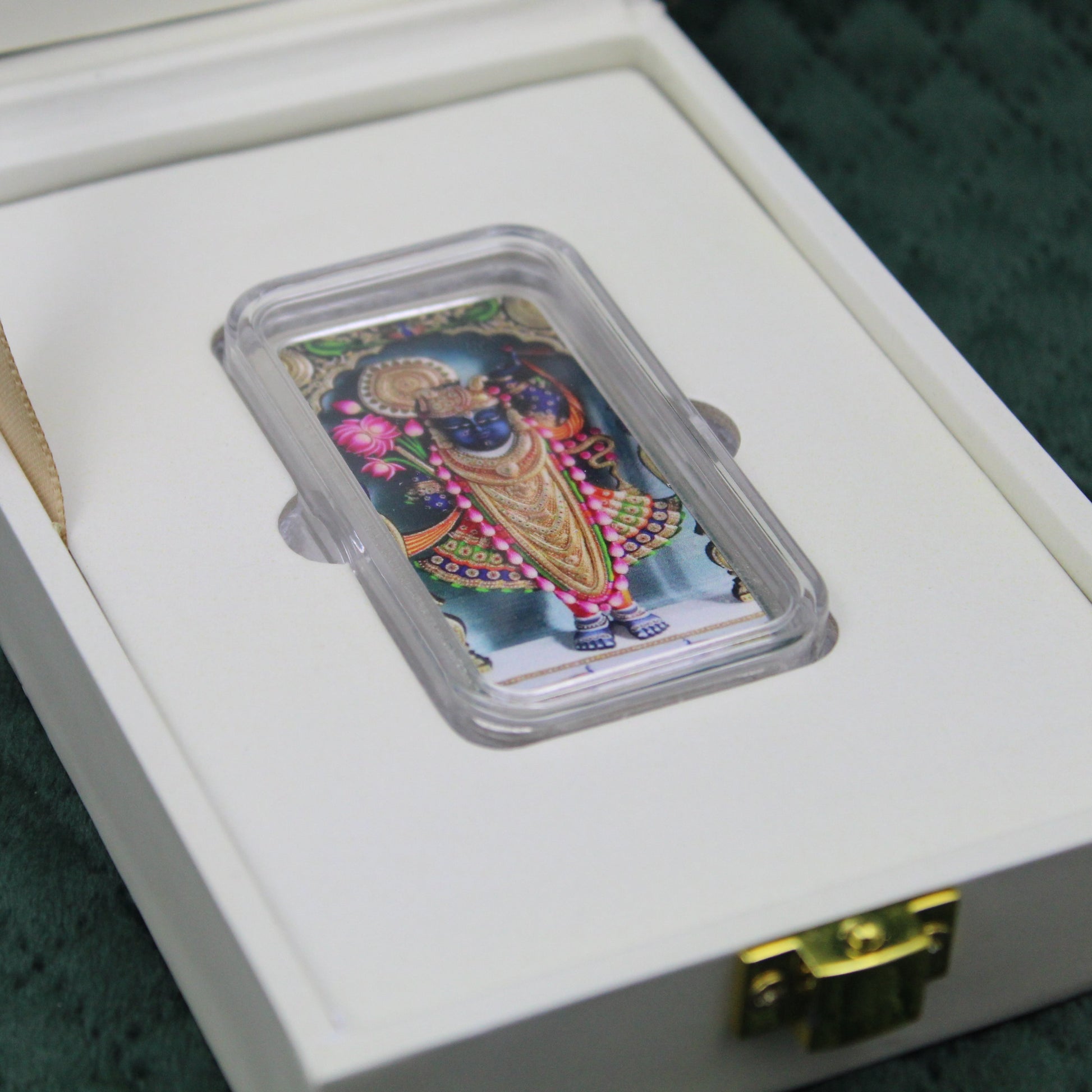 Decorative Coin in a clear plastic holder on a white box with gold latch.